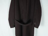 manteau en laine marron avec une ceinture, suspendu à un cintre sur fond blanc