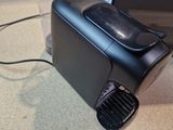 a black coffee maker sitting on a table next to a toaster