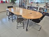 tables and stools in a room with bookshelves in the background