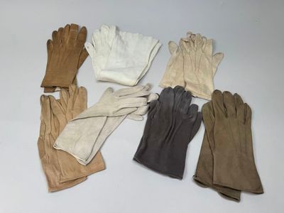cinq paires de gants empilées les unes sur les autres sur une table
