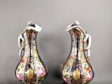deux vases ornés de motifs floraux, posés sur une table