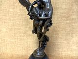 une image représentant une statue en bronze d'un ange tenant un bébé dans ses bras