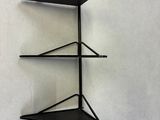 a black metal shelf with three shelves on it