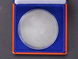 a close up of a silver coin in a blue and orange box