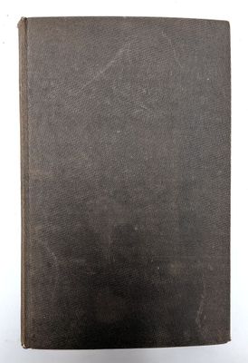 un vieux livre à la couverture noire posé sur une surface blanche