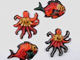 quatre poissons de couleurs différentes sur un fond blanc
