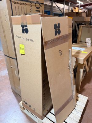 Les cartons sont empilés sur des palettes dans un entrepôt et sont munis d'une étiquette de prix.