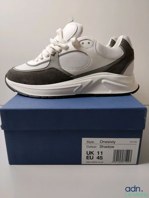 a pair of white and black sneakers sitting on top of a blue box