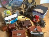 beaucoup de vieux appareils photo et d'autres objets sur la table