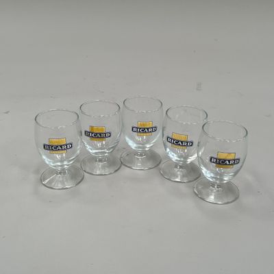 quatre verres vides posés les uns à côté des autres sur une table blanche