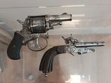 two revolvers that are on display in a glass case
