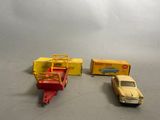 three toy cars and a truck on a table