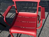 a red chair and a black table in a parking lot