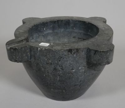 a black vase with a tag on it on a white surface