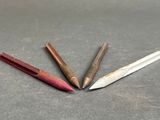 three different colored pencils sitting on top of a gray surface