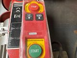 a red machine with a yellow button on it