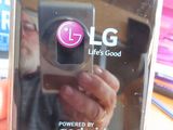 a person taking a picture of a cell phone with the lg logo on it