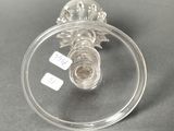 a clear glass object on a table with a tag on it