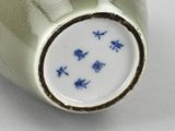 a green vase with a blue and white design on it