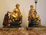 deux statues représentant un homme et une femme assis sur une table en marbre