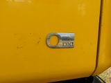 a close up of a yellow truck ' s door handle