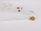 trois bijoux posés sur une surface blanche