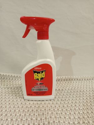 a close up of a bottle of raid insect repellent on a table