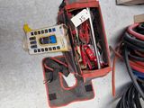une boîte contenant du matériel électrique posée par terre à côté d'une boîte de câbles