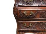 an old wooden chest of drawers with carvings on top of it