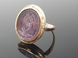 a close up of a gold ring with a purple stone in it