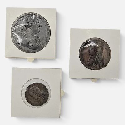 Trois types différents de pièces d'argent et de bronze sont exposés sur un fond blanc