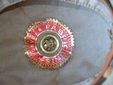 a close up of a red and gold badge on a hat