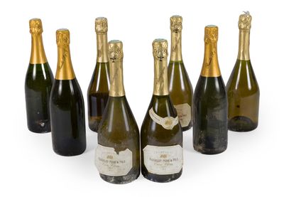 six bottles of champagne are lined up on a white surface