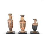 three vases are sitting on top of a wooden stand
