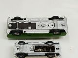 two toy cars sitting side by side on a white surface