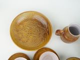 a bowl and cups on a table next to each other