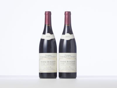 two bottles of wine sitting on top of a table next to each other