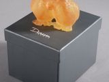 a small orange bear sitting on top of a black box