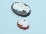 two small cameos of a sheep and a sheep on a plate