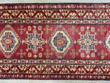 a close up of a red and blue rug on a white floor