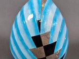 a blue vase with a black and white design on it