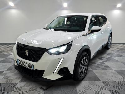 la voiture blanche est garée dans une grande pièce au sol en damier