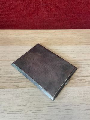 a small book sitting on a table with a red chair in the background