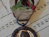 une médaille sur laquelle figure l'image d'un homme, posée sur un morceau de papier