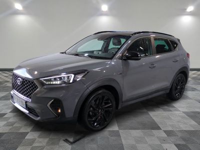 un SUV gris garé sur un sol à damier dans un garage