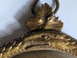 a close up of a gold clock with a bird on it