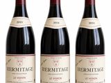 three bottles of red wine sitting next to each other on a white surface