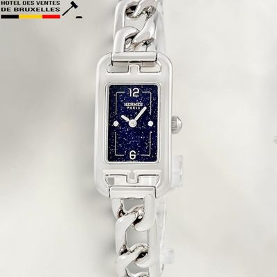 a silver watch with a blue face on a chain bracelet