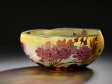 un bol jaune orné de fleurs rouges posé sur une table