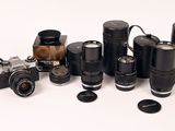 tout un tas d'appareils photo et d'objectifs différents posés sur la table